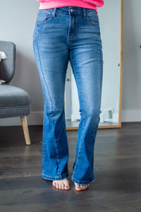 Model standing forward wearing flare jeans